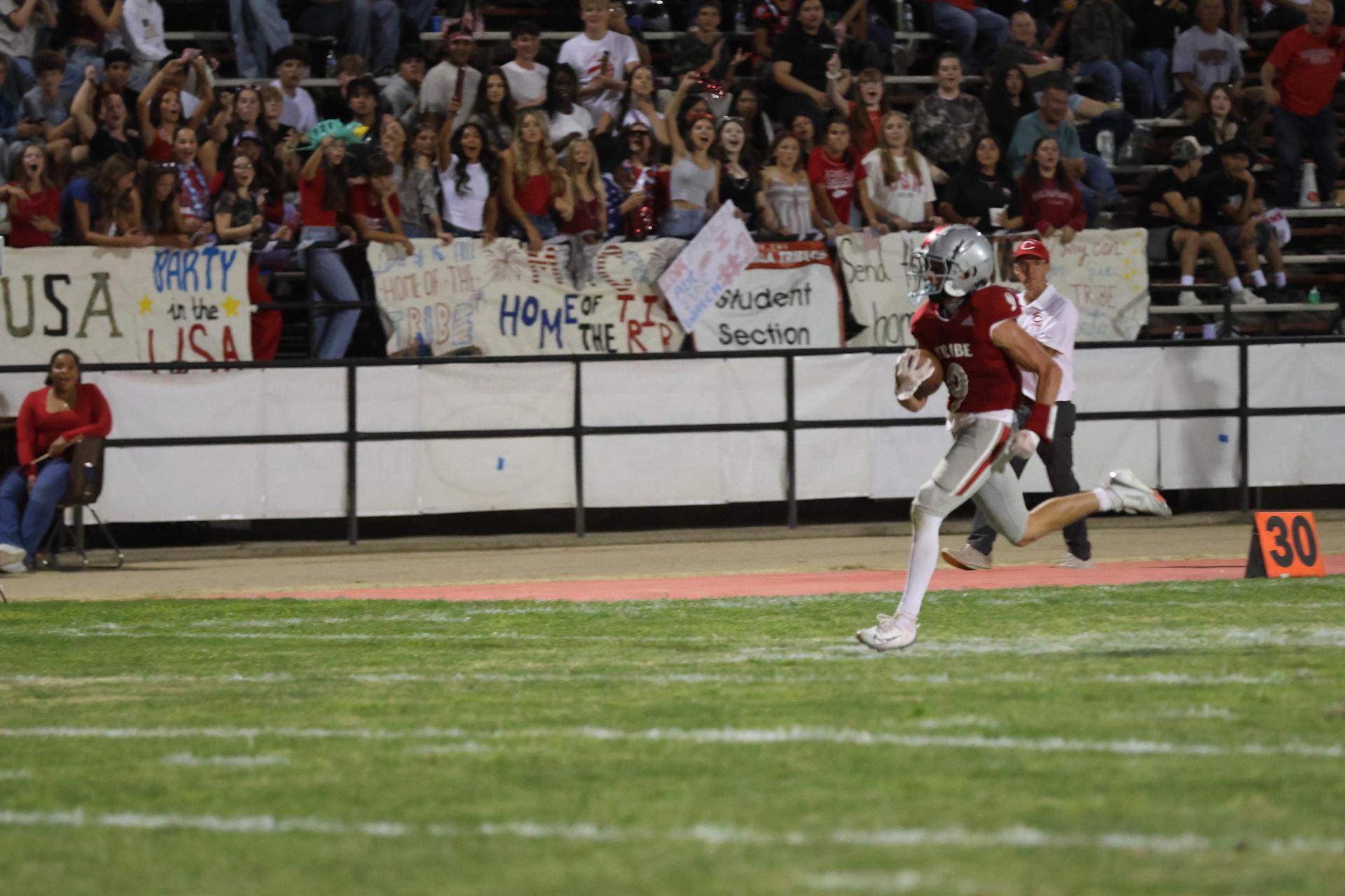 Varsity football players in action against Parlier 25