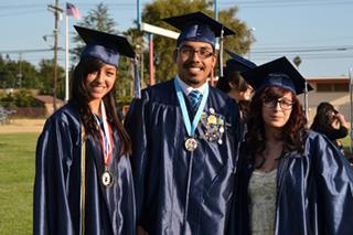 three students in graduation regalia