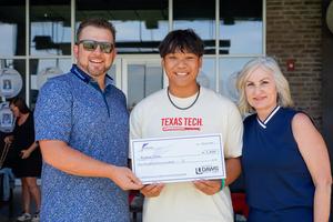 student receives his check from foundation members