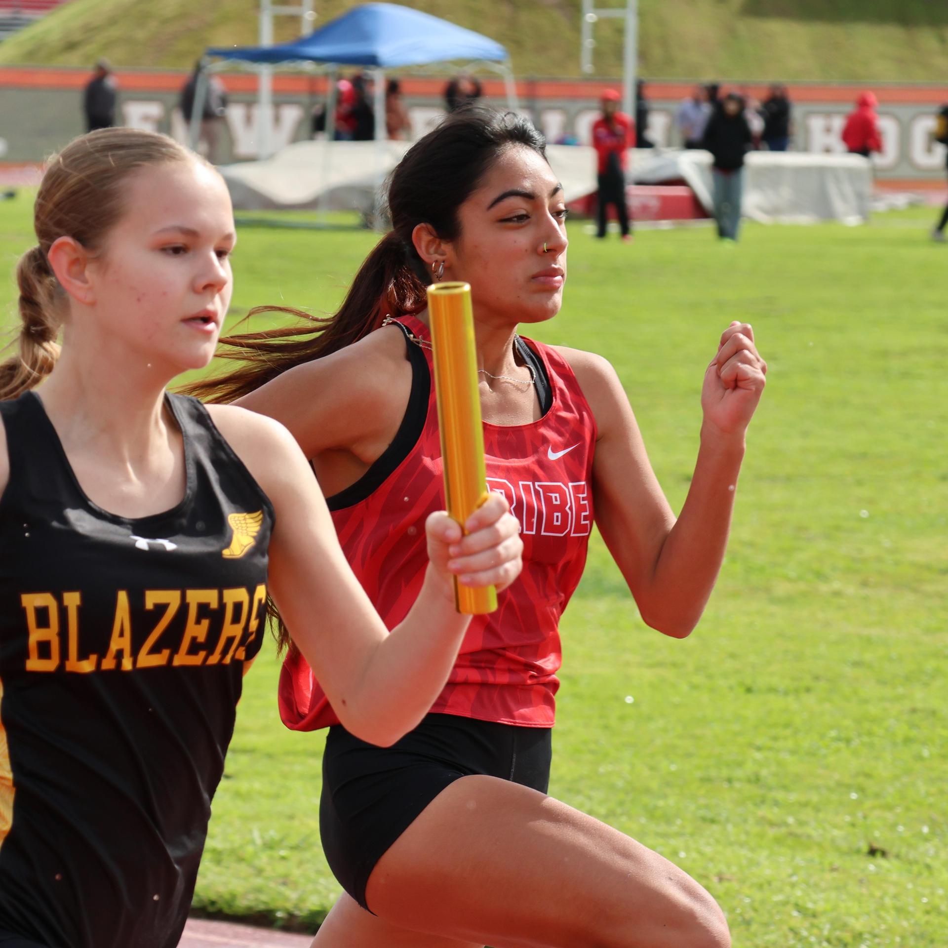 girls running the four by 100 meter relay