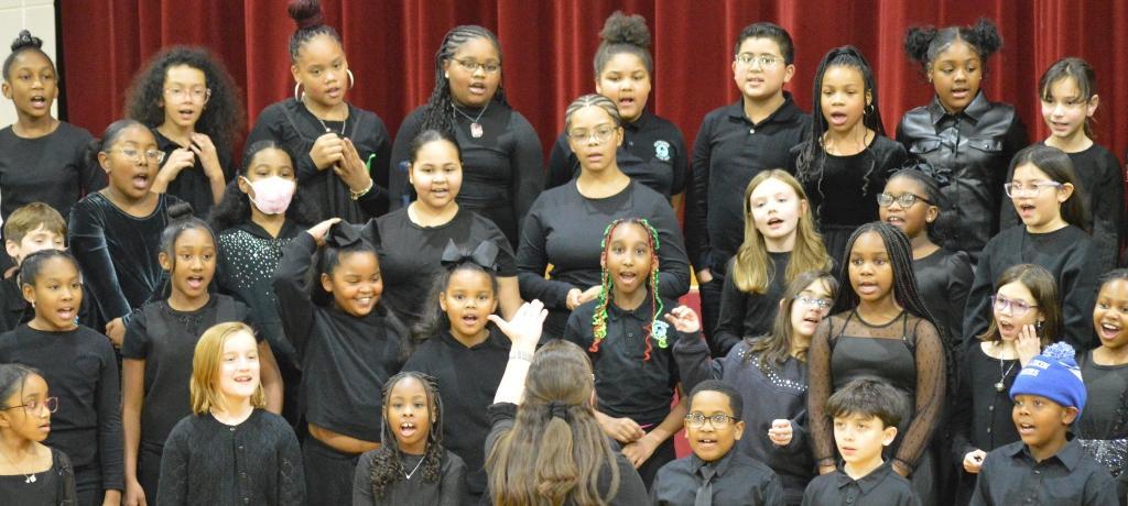 teacher directing singing students