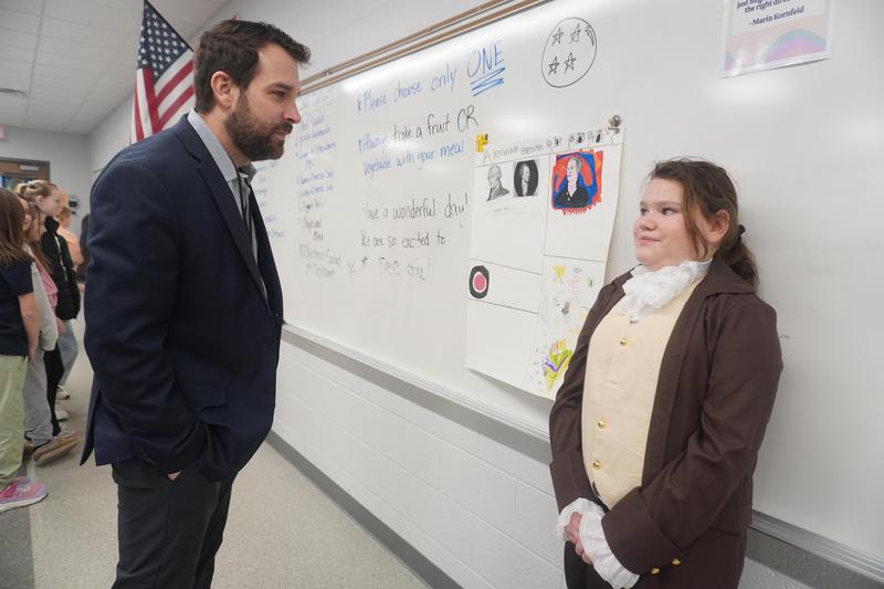 Superintendent Rob Pouch listens to a Page student recite her script at the Wax Museum.