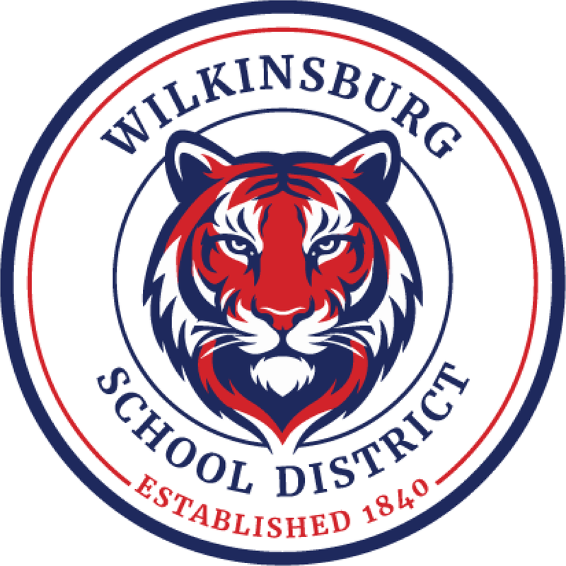 A red and blue tiger face, inside a seal that reads Wilkinsburg School District, Established 1840