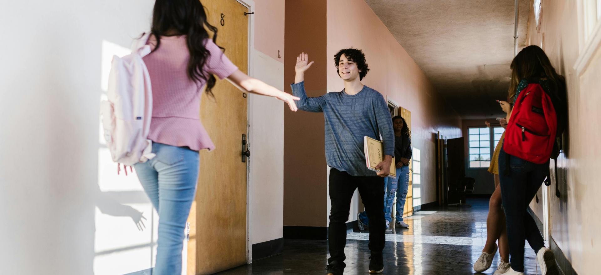 Two students greet each other