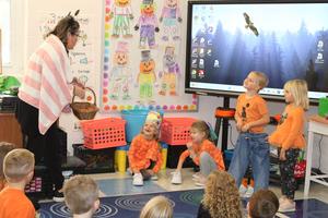 teacher reciting an interactive story to smiling kindergarteners