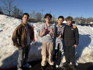 students standing in front of snow pile