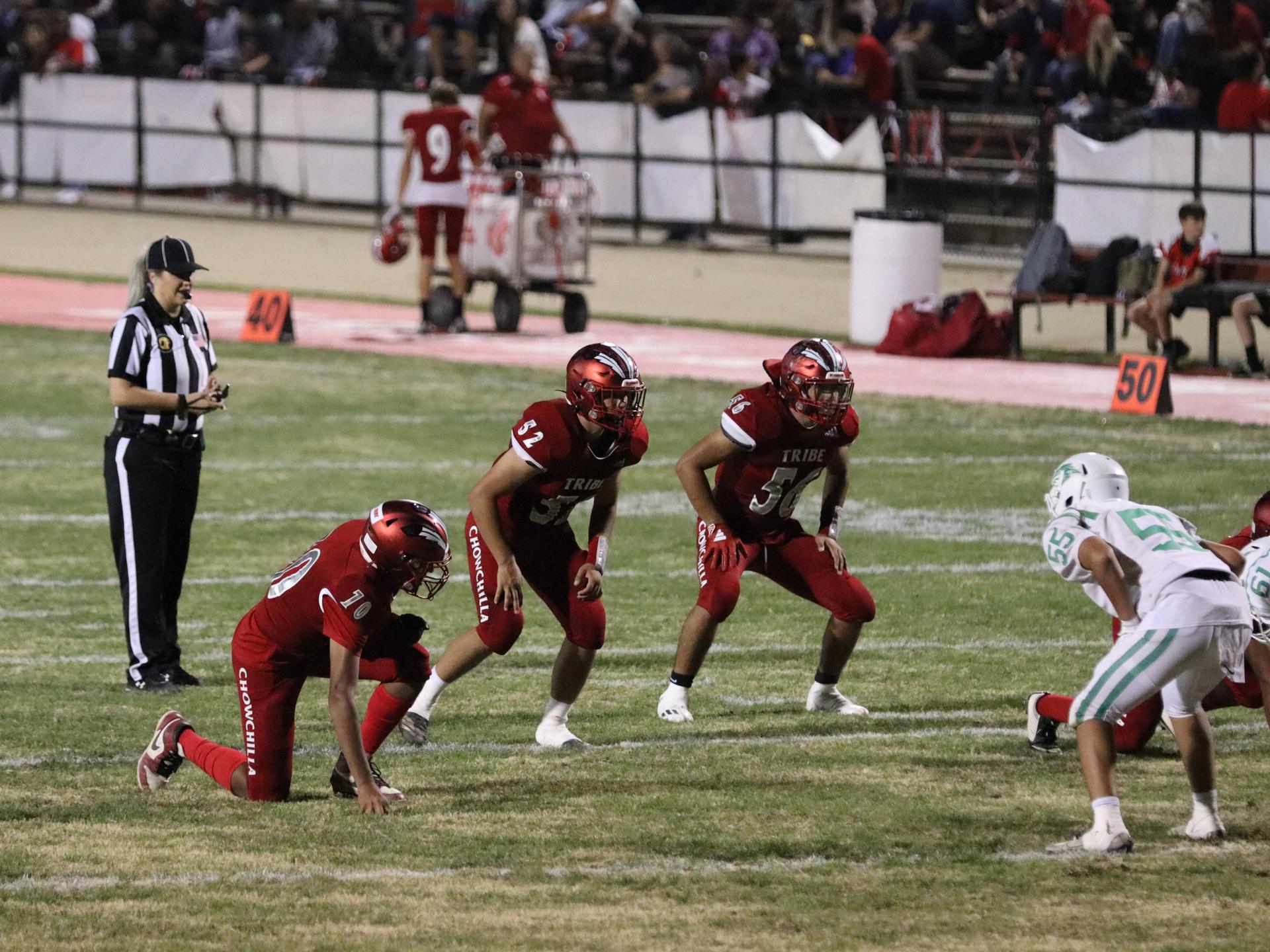 varsity football players in action against Riverdale