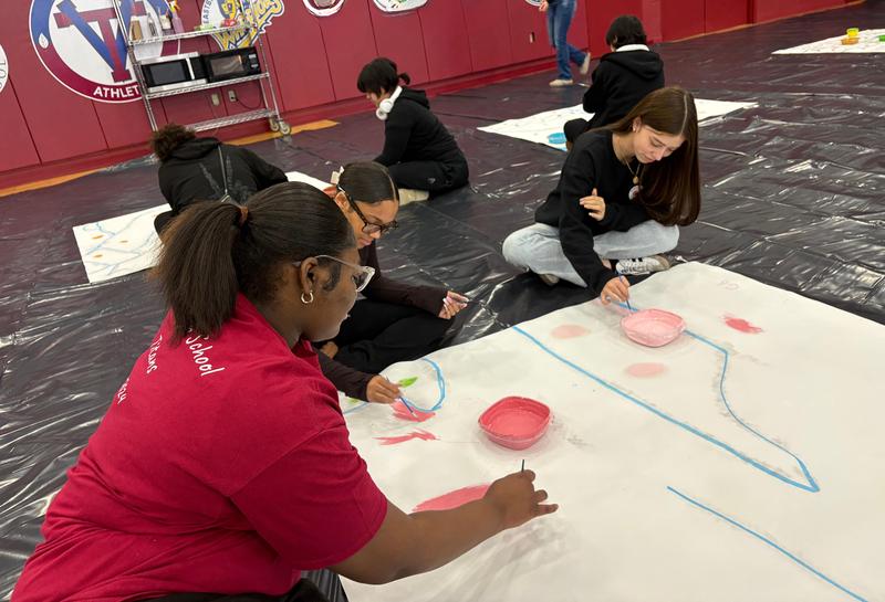 Three Tenor High School students painting mural panels