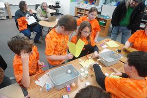 Team members work to build a bridge across two baskets.