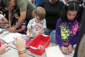 student counting how many pennies can be added to aluminum foil boat before it sinks.