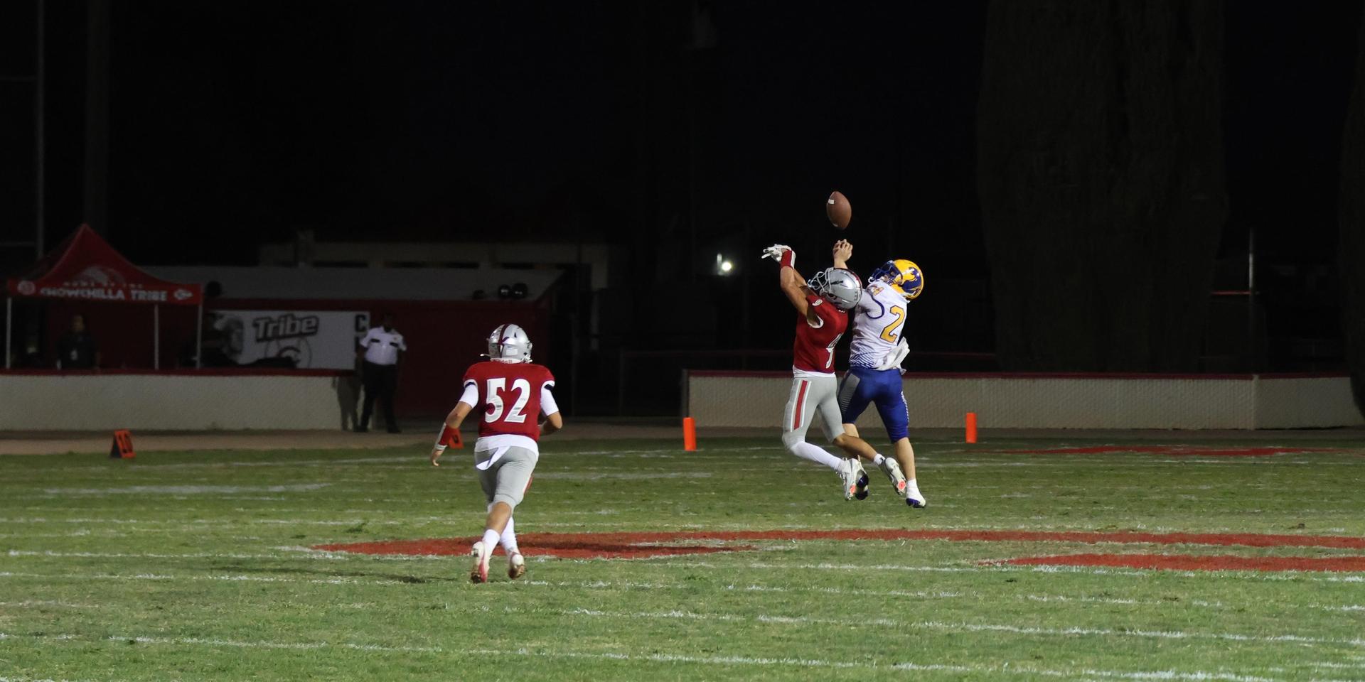 Varsity football players in action against Parlier 12