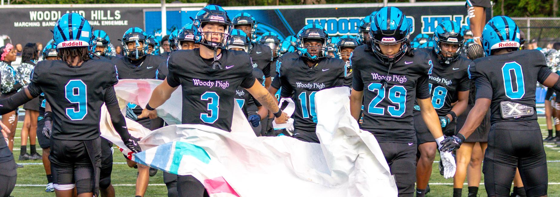 Woodland Hills football team runs onto the field