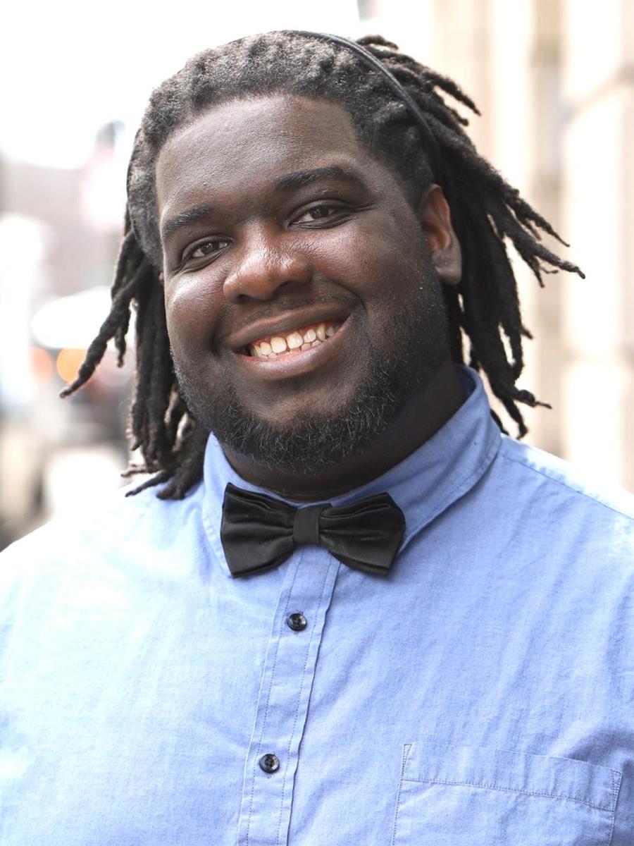 Head shot, smiling wide, blue shirt and bow tie — Courtney Dailey