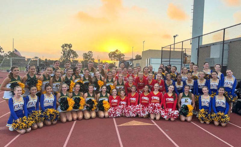 Cheerleading squads in colorful uniforms posing together at sunset.