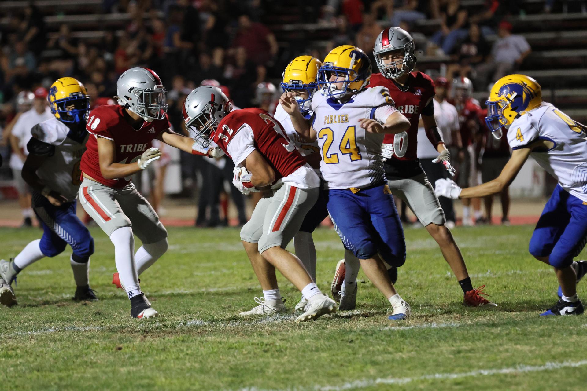 Varsity football players in action against Parlier 111
