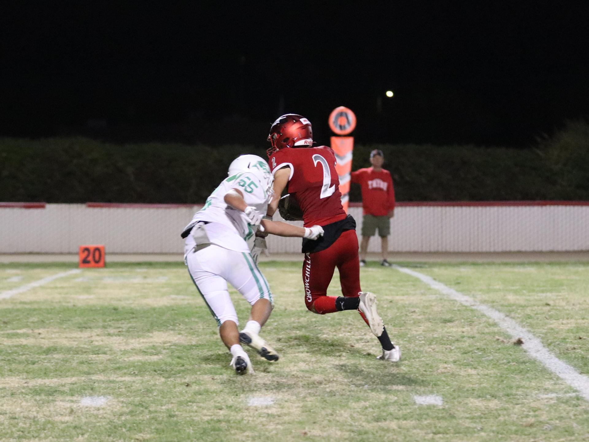 varsity football players in action against Riverdale