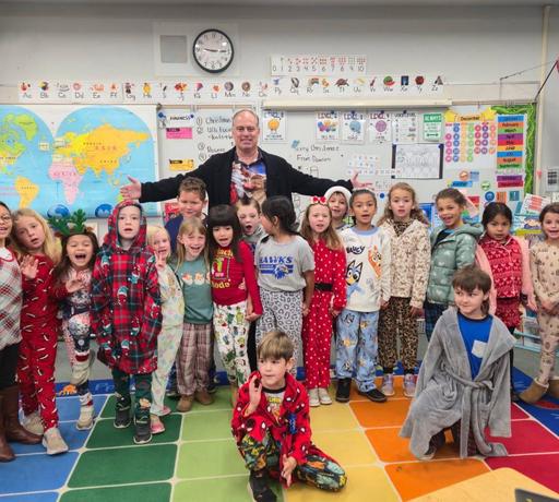 Superintendent Beck with Elementary Students.  Students are in pajamas for PJ Day before Christmas Break