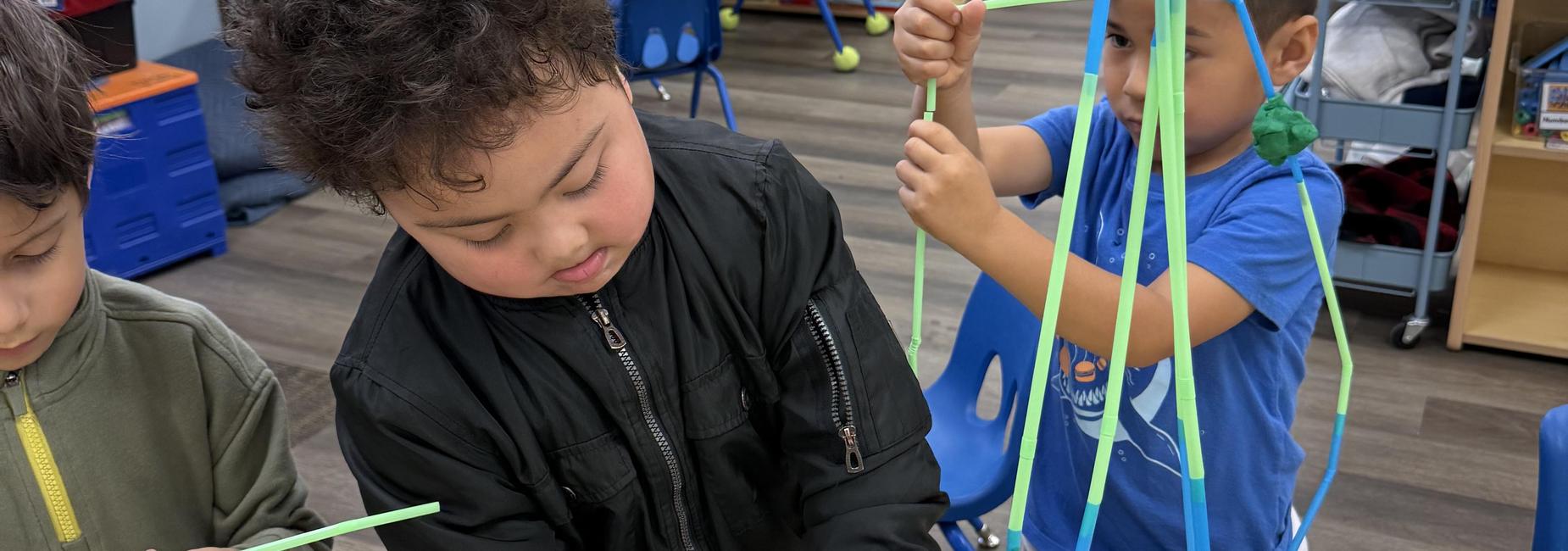 Students is building with straws and playdough.