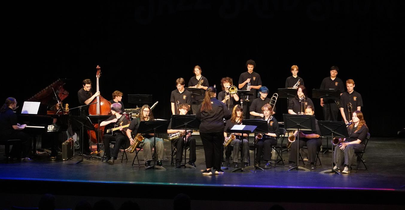 A jazz band performing on stage with various instruments and musicians.