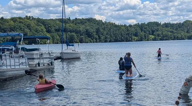 lake view with kids paddling kayaks and paddleboards