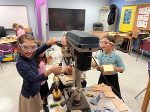 Three students work with Rabbi Rubin on their Tzedakah Boxes.