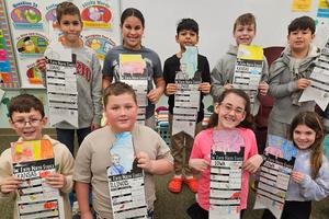 Third-grade students hold up their state reports, including (front) Aidan Simak, Gavin Chamberlain, Leah Yeager, Kylee Guarino, (back) Jonah Jones, Madison Laird, Malachi Krautz, Milo Lemmon, and Leo Molina