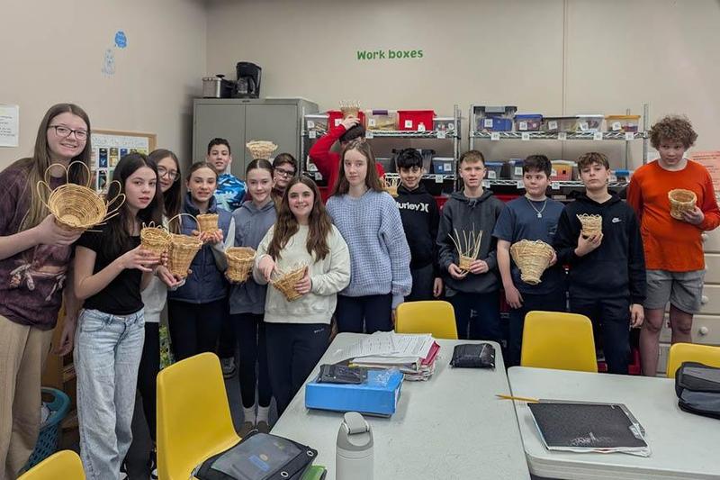 Students in the art class hold their finished basket projects