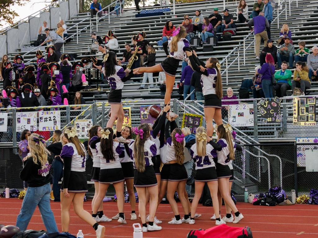 Cheerleaders in a tower formation during a football game.