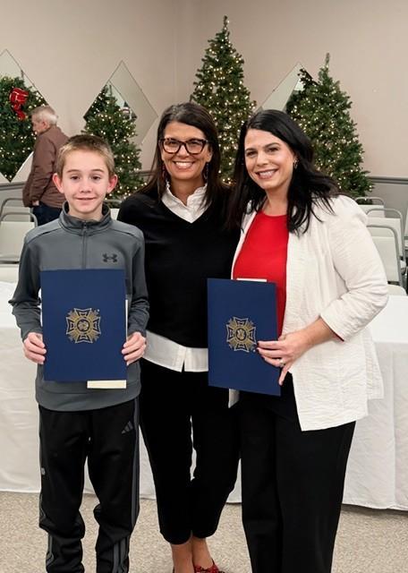 principal, teacher, and student pose with awards