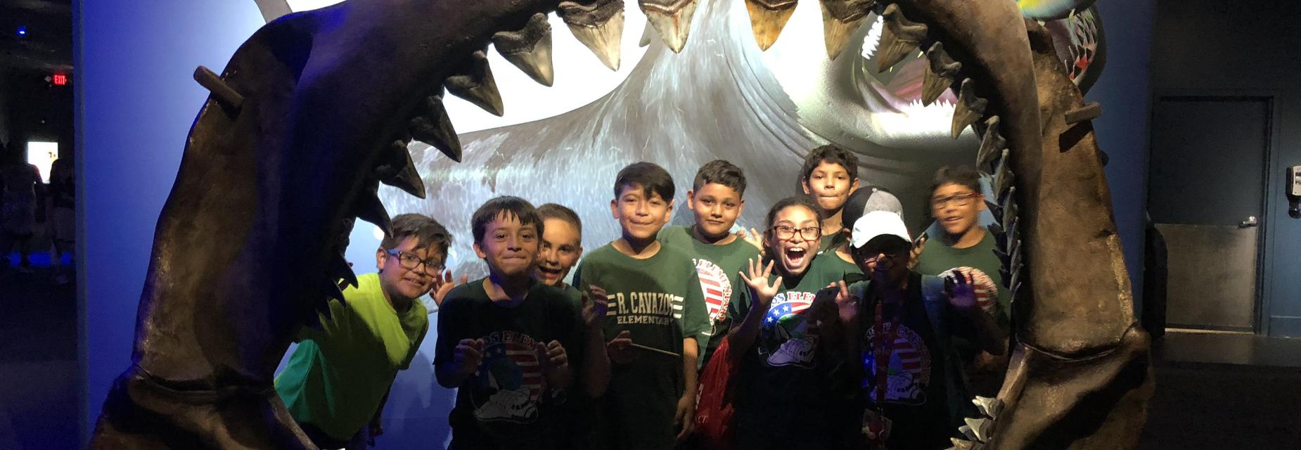 students inside of shark mouth skeleton