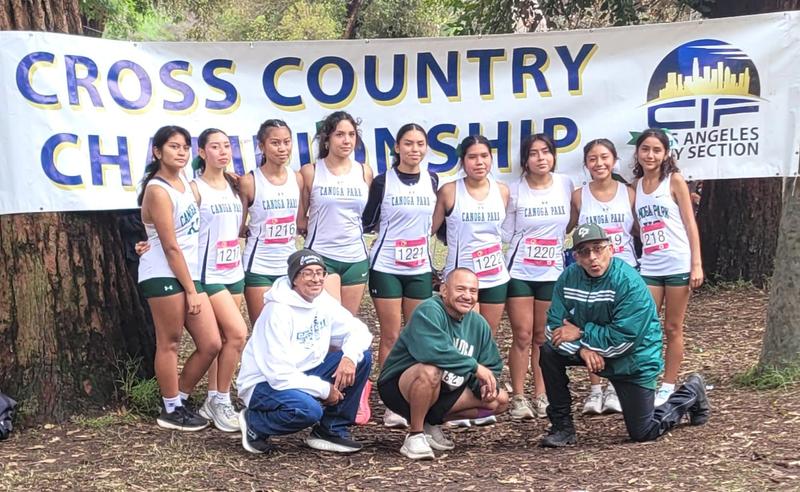 Girls Cross Country team pose with coaches at competition
