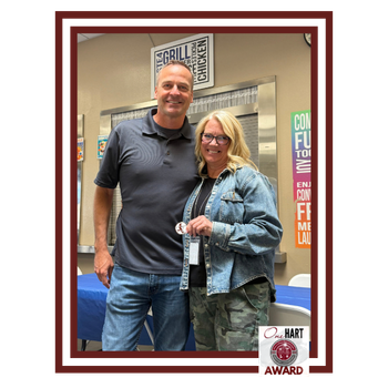 Photo of a man and a woman holding an award