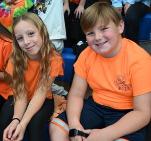 Two students wearing orange shirts