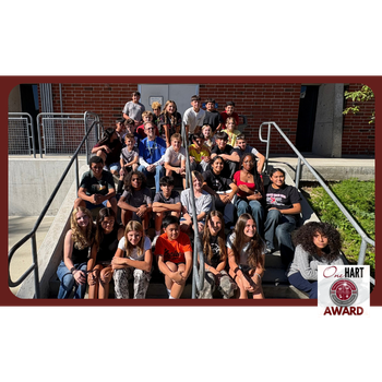 Photo of a group of students with a teacher, seated on a staircase