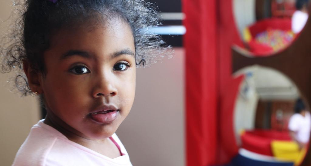 A young child with curly hair in a playful environment.