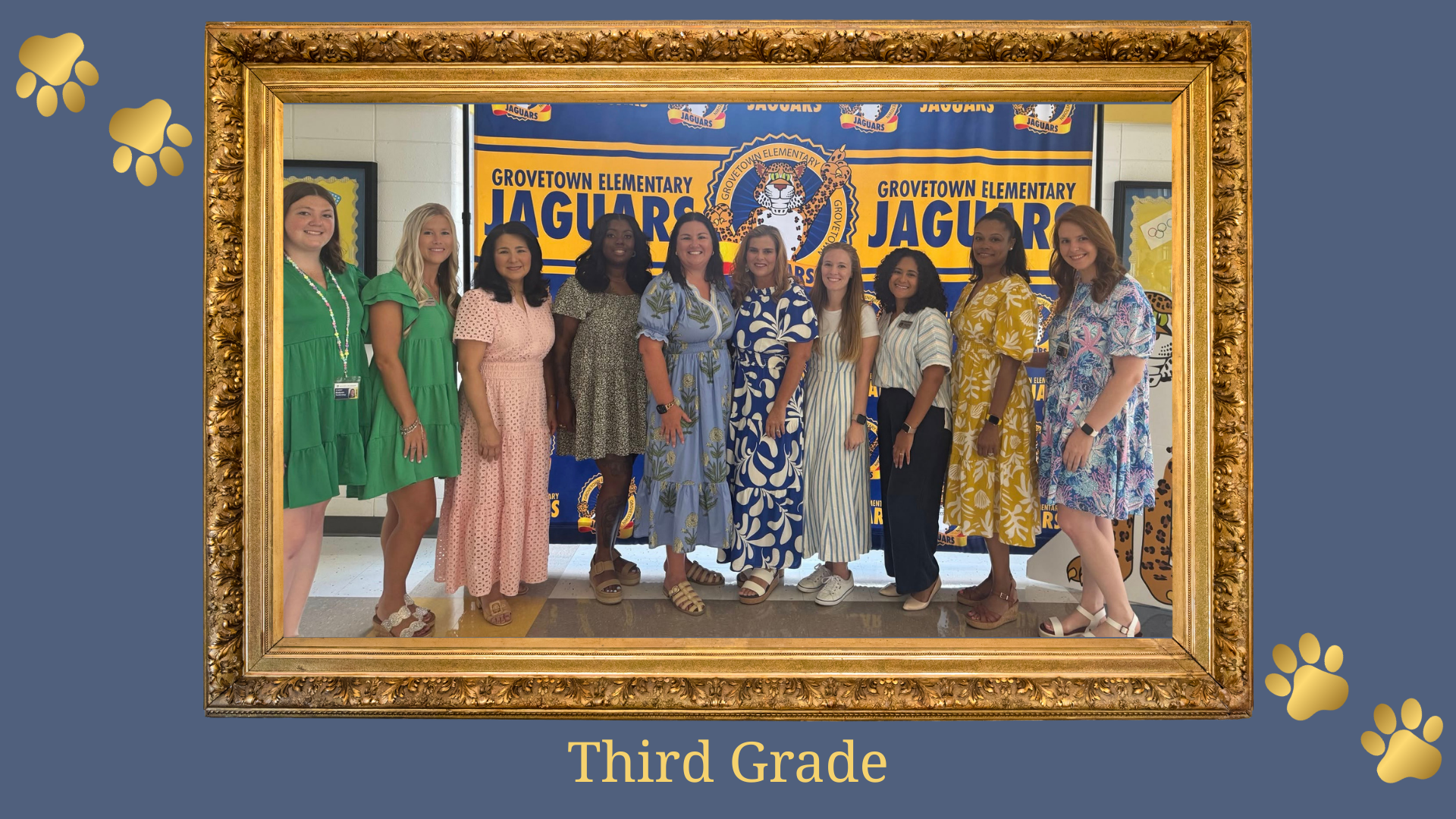 Third grade teachers posing cheerfully in front of a Jaguar-themed backdrop.