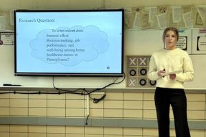 Student presenting a research question related to healthcare and burnout.