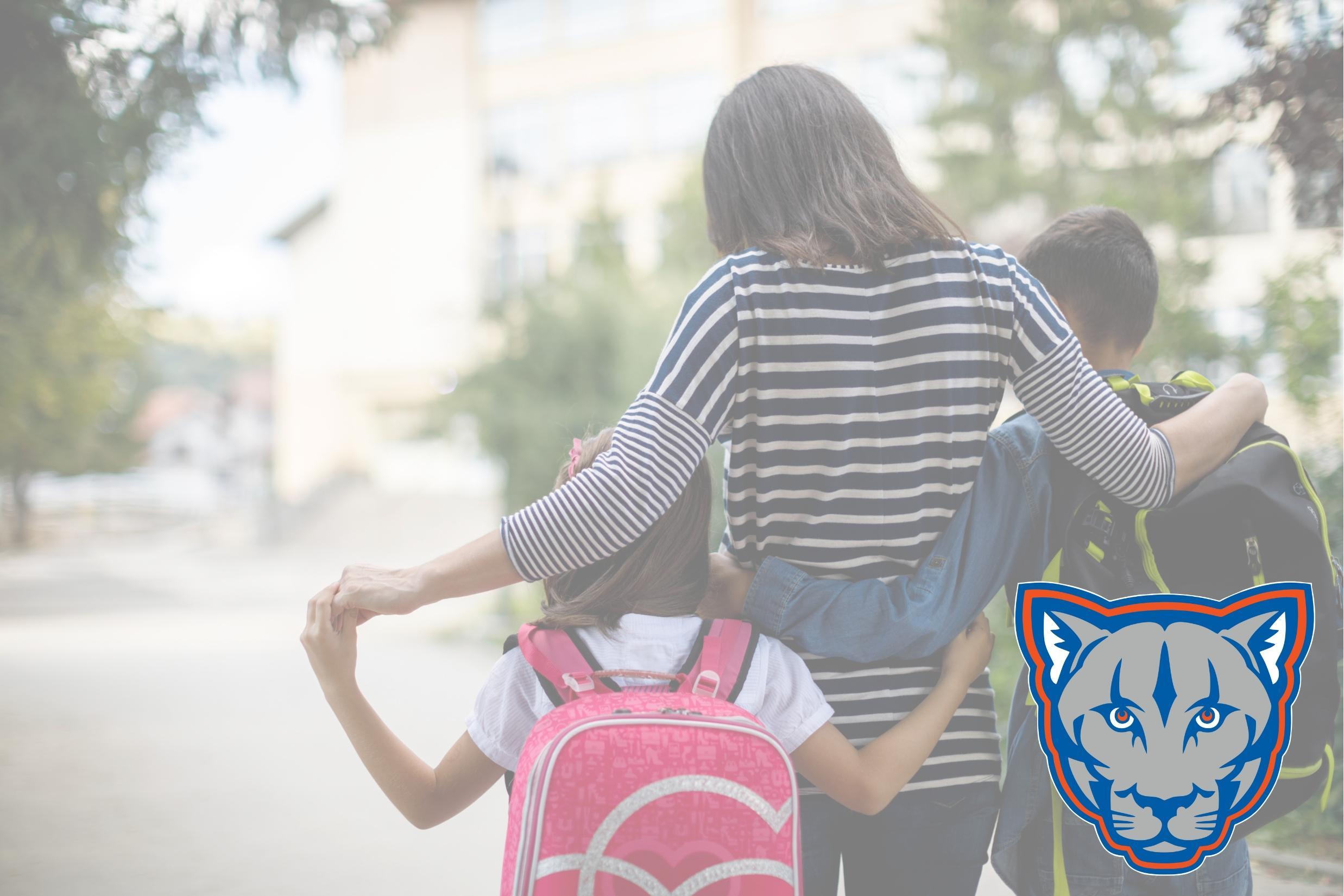 woman walking with two children wearing backpacks