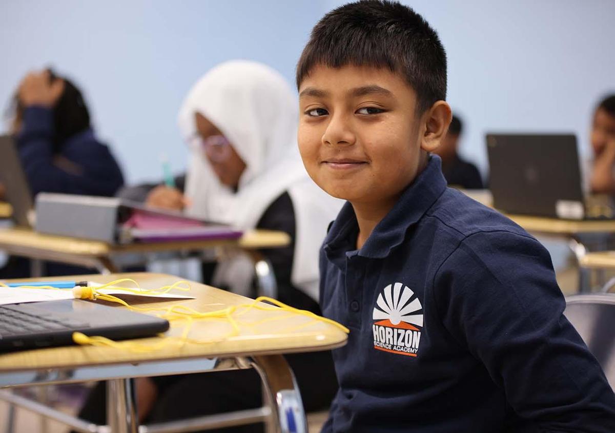 HSA Columbus Middle School student smiling and posing together in a classroom.