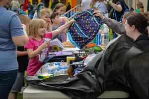 An MCS student is handed a backpack.