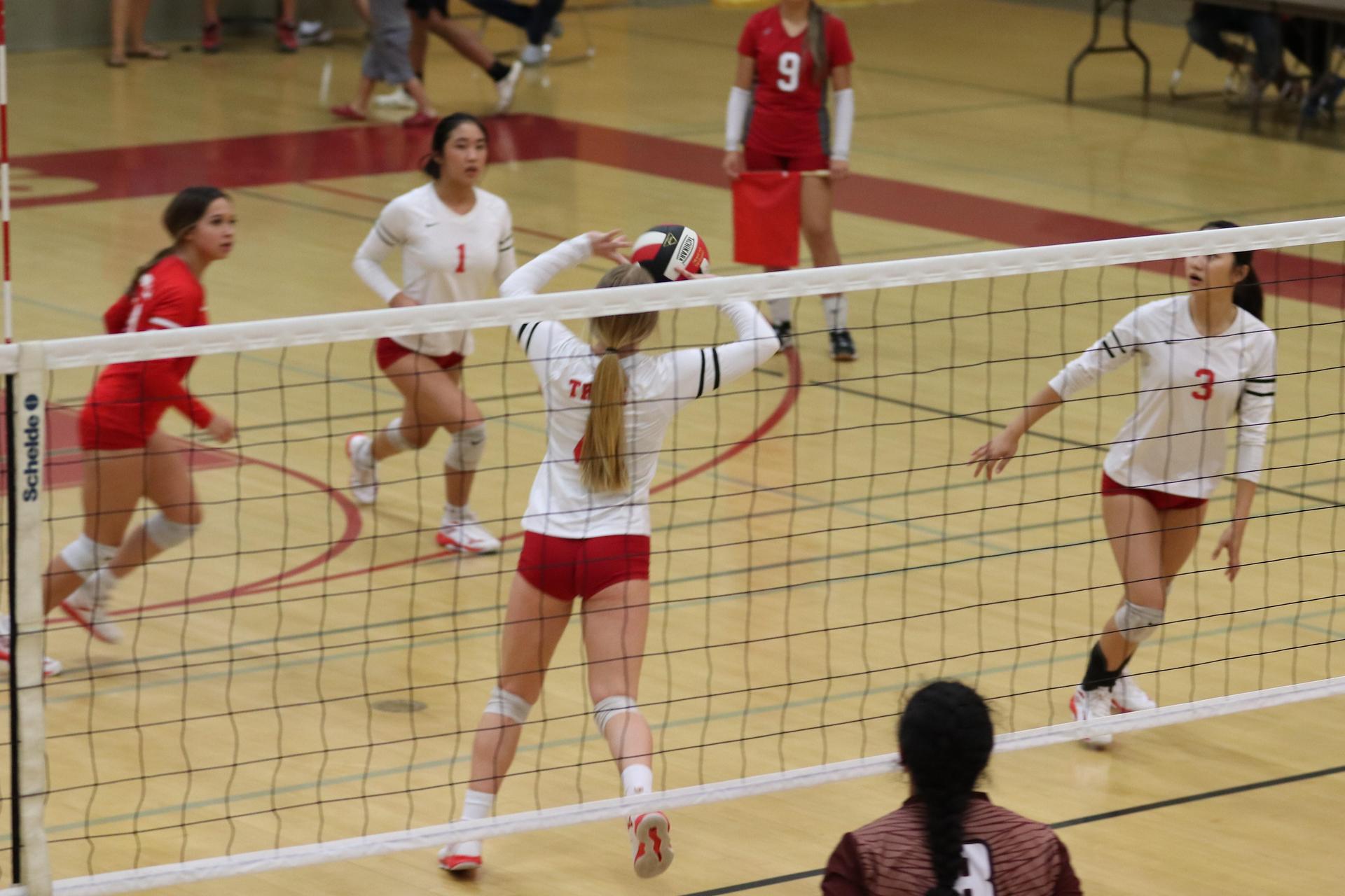 varsity volleyball players in action against Fresno Christian