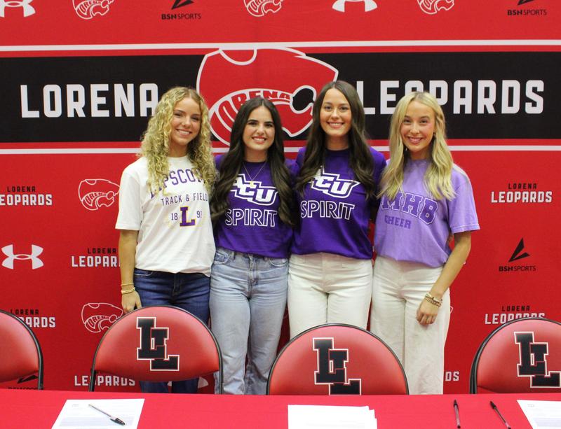 Four students satding in from of a red and black Lorena Leopard back drop