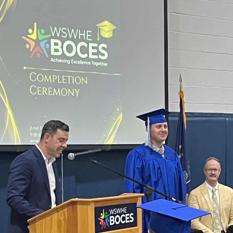 student near podium with cap and gown