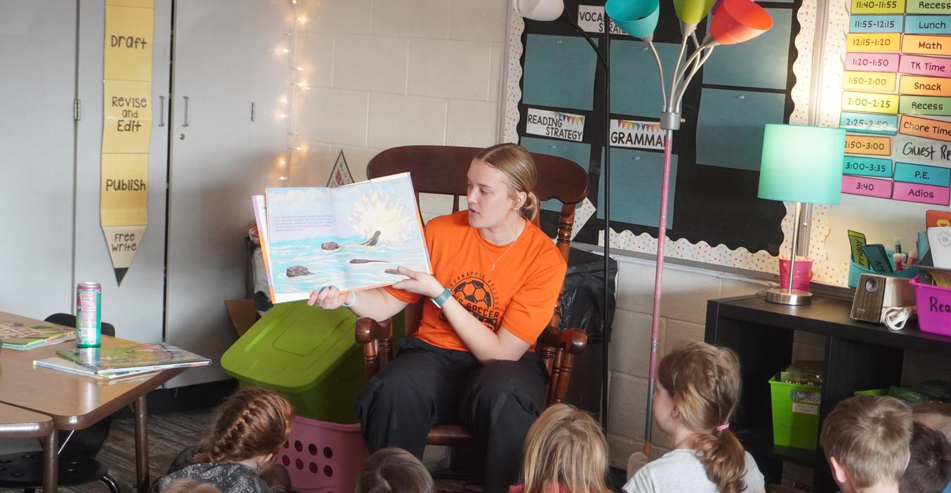 A high school student reads to Lee Elementary students.
