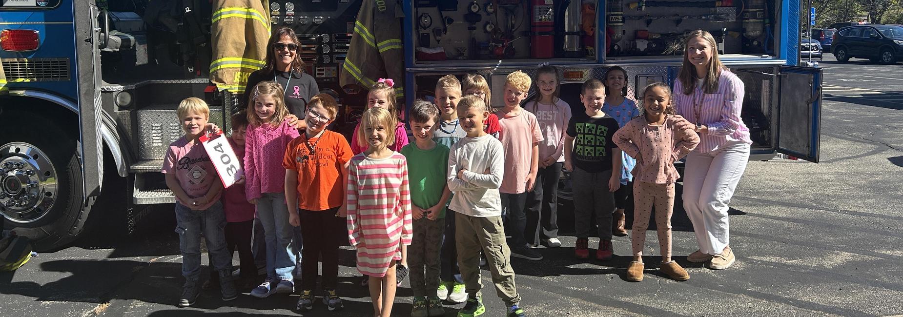 students posing in front of fire truck