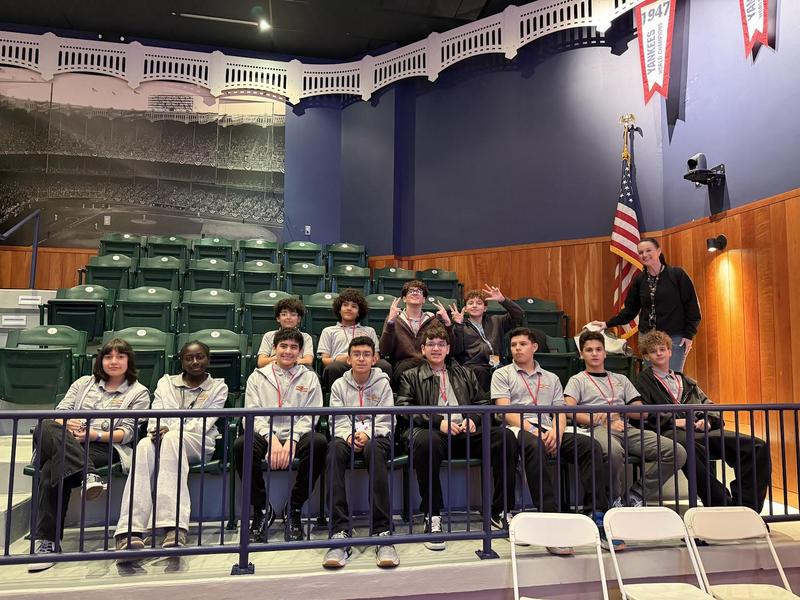 students in stadium seats at the museum