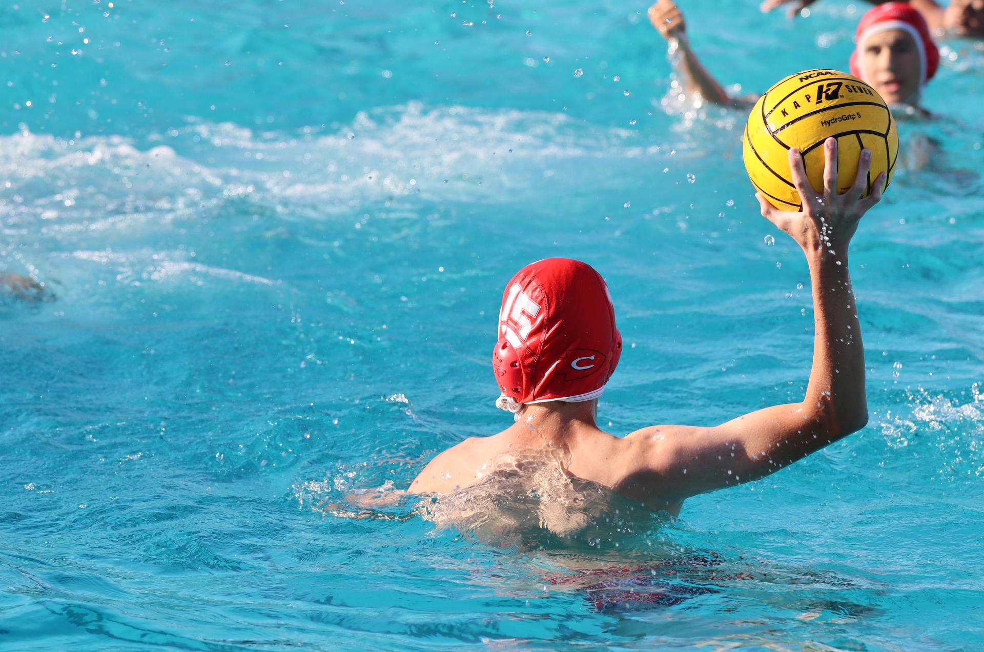 boys water polo players in action against hoover