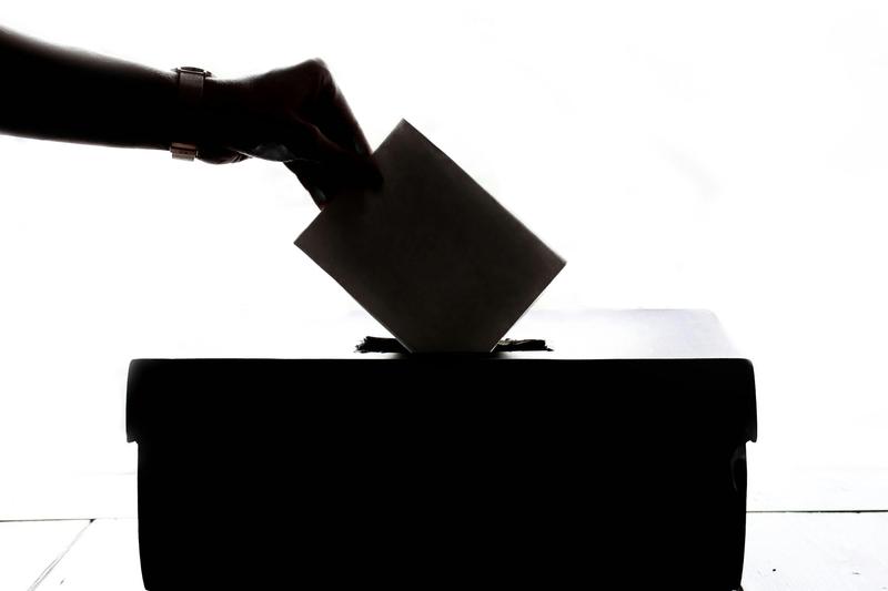 a person placing a ballot in a box