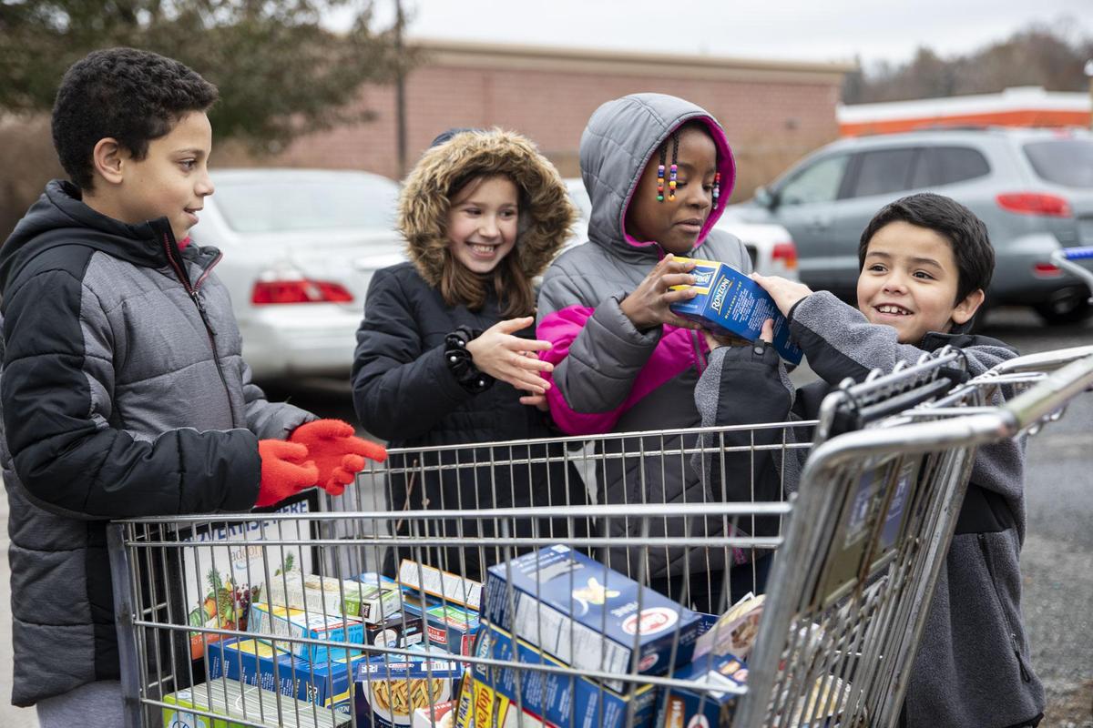 Hop Brook students stack grocery cart with food for the food bank