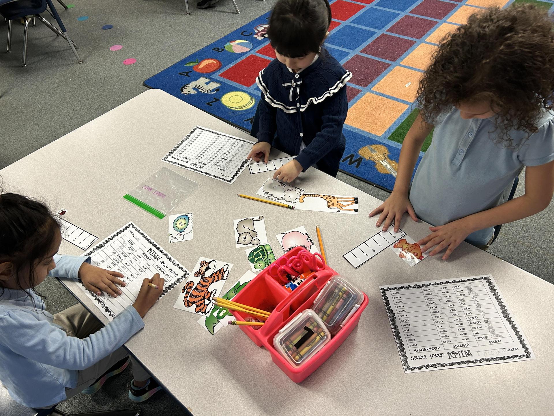 Students at a table with measuring tools